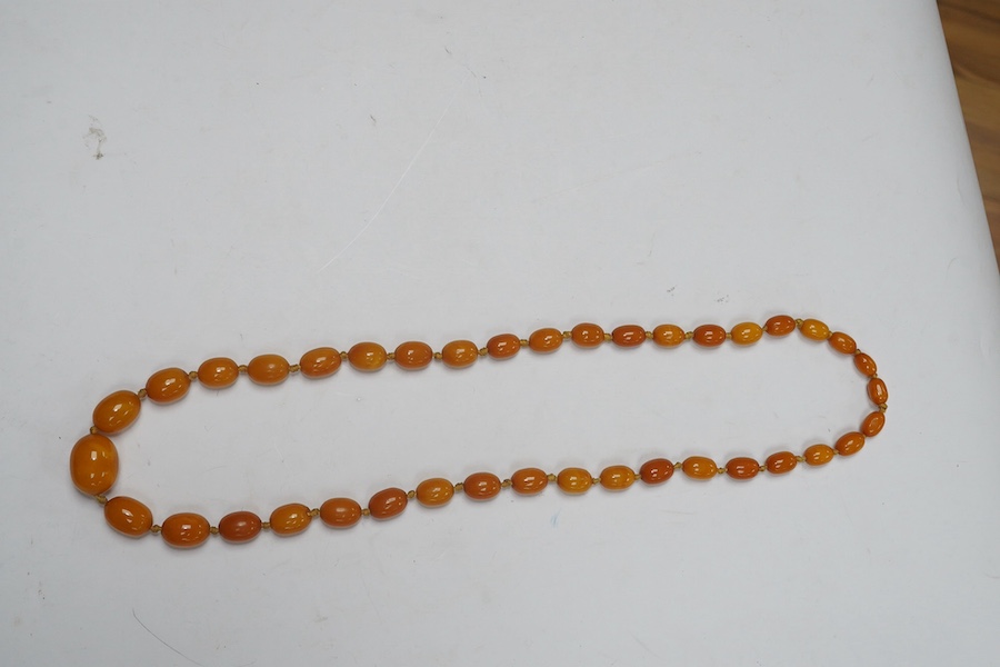 A single strand graduated oval amber bead necklace, 62cm, gross weight 34 grams. Condition - poor to fair